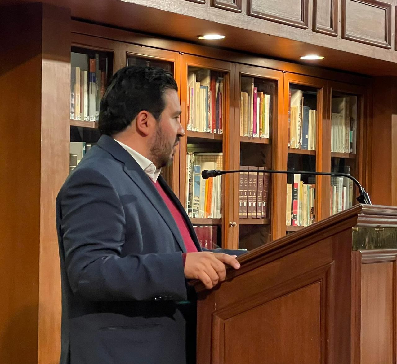 Francisco Javier Belgodere Hernández dando un discurso en tribuna, biblioteca formal